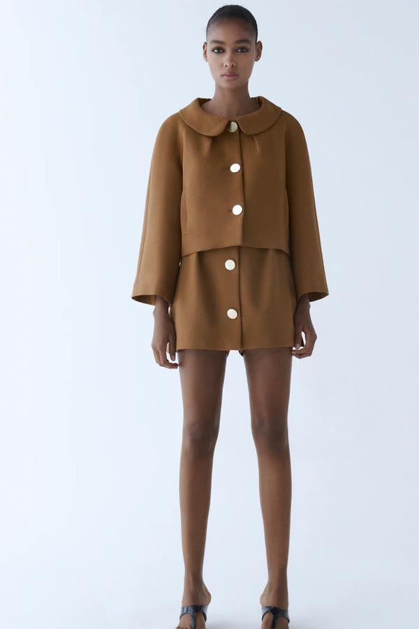 En color toffe, este conjunto está formado por falda bermuda (25,95 euros) de tiro alto con detalle frontal de botones metálicos y blazer (49,95 euros) cropped con cuello bobo y manga larga amplia.