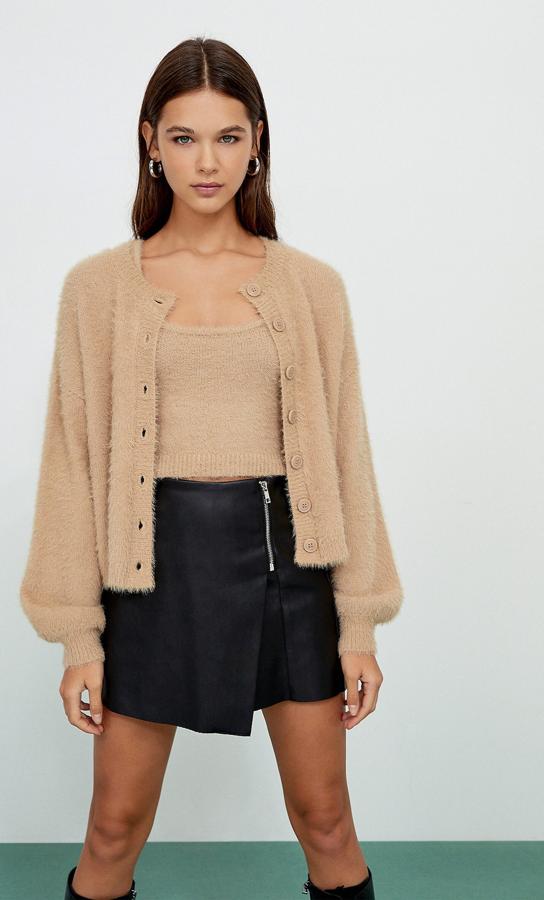En Stradivarius apuestan por el beige para este conjunto compuesto por un top de escote redondo y tirantes (12,99 euros) y un cárdigan con cuello redondo y manga larga(19,99 euros), ambos de tacto suave. Disponibles también en azul y crudo, podemos encontrarlos entre las tallas XS y L.