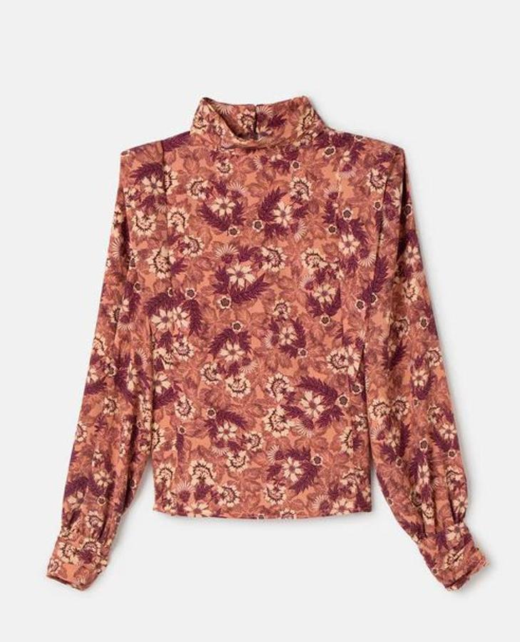Blusa con pliegues en los hombros para crear un efecto hombrera, con estampado de flores en tonos maquillaje, de Fórmula Joven. Cuesta 39,99 euros y está a la venta en El Corte Inglés.