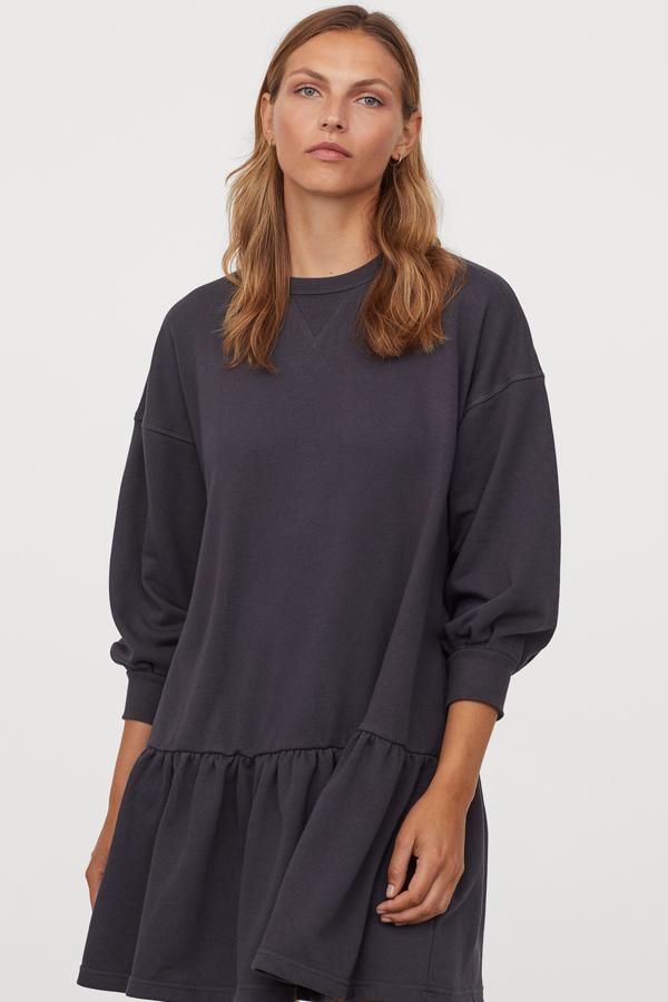 Este vestido corto en tejido de sudadera está disponible en color gris, crema o verde caqui. Con mangas largas amplias y costura fruncida en la cadera, tiene un precio de 24,99 euros.