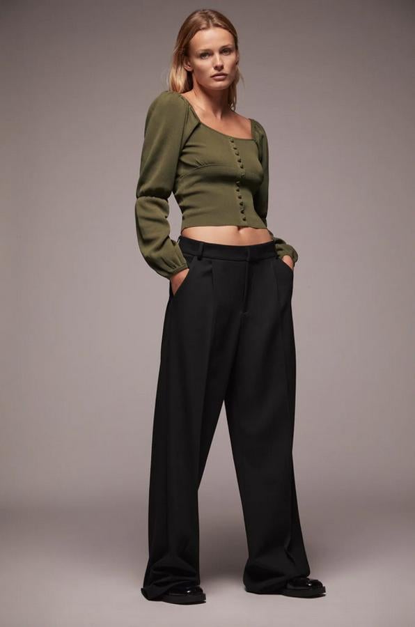 Diseño ajustado con escote recto y manga larga abullonada con elásticos para este top de Zara en color caqui con detalle de falsos botones delanteros forrados a tono. Podemos encontrarlo en las tallas S, M y L por 25,95 euros.