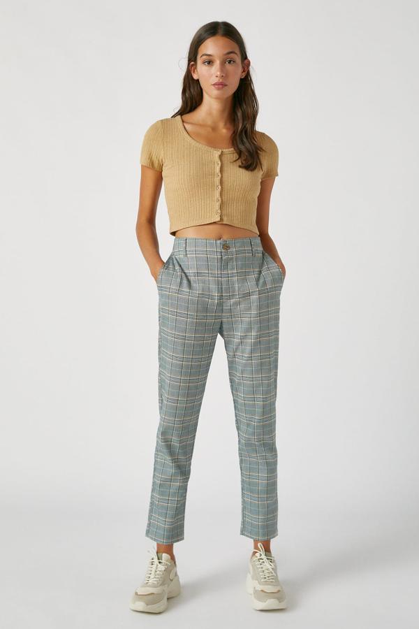 Este pantalón con estampado de cuadros en tonos grises cuenta con cintura con trabillas y cierre mediante botón y cremallera. Es de Pull & Bear y tiene un precio de 19,99 euros.