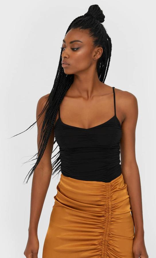 Este body drapeado en color negro cuenta con tirantes ajustables y tiene un precio de 15,99 euros.