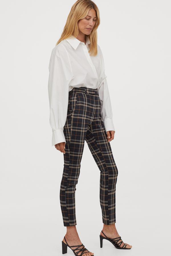 En color negro con estampado de cuadros beige, este pantalón pitillo en tejido elástico es de H&M y tiene un precio de 19,99 euros.