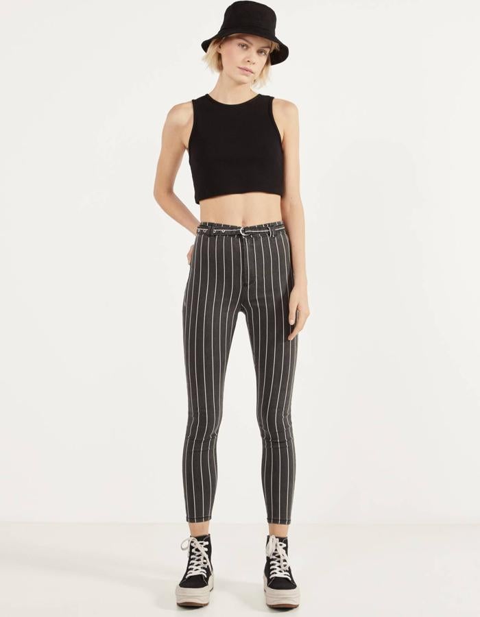 En color negro con raya fina en blanco, este pantalón de talle alto cuenta con detalle de cinturón fino. Es de Bershka y tiene un precio de 15,99 euros.