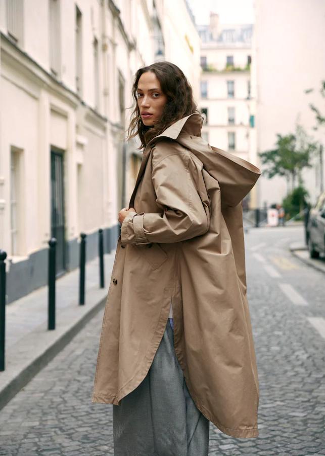 Estaba disponible de la XS a la XL, pero la M y la talla más grande están ya agotadas. De mezcla con algodón, el tejido es water repellent. El largo midi, el cuello redondo y las aberturas laterales consiguen una silueta impactante. Además, incluye una capucha desmontable de lo más funcional.