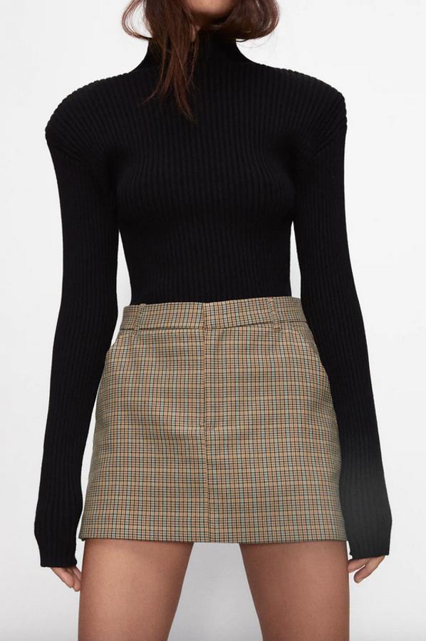 Estampado de cuadros en tonos naranjas y azules sobre fondo beige para esta falda pantalón de tiro alto de Zara con bolsillos laterales. Tiene un precio de 19,95 euros y está disponible entre las tallas XS y XL.