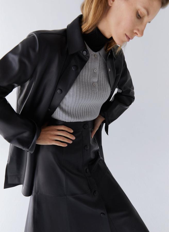 Cuello camisero y cierre de botones de clip forrados en piel para esta camisa negra confeccionada en piel de alta calidad con aberturas laterales en el bajo asimétrico. Con un precio de 199 euros, está disponible en las tallas S, M y L.