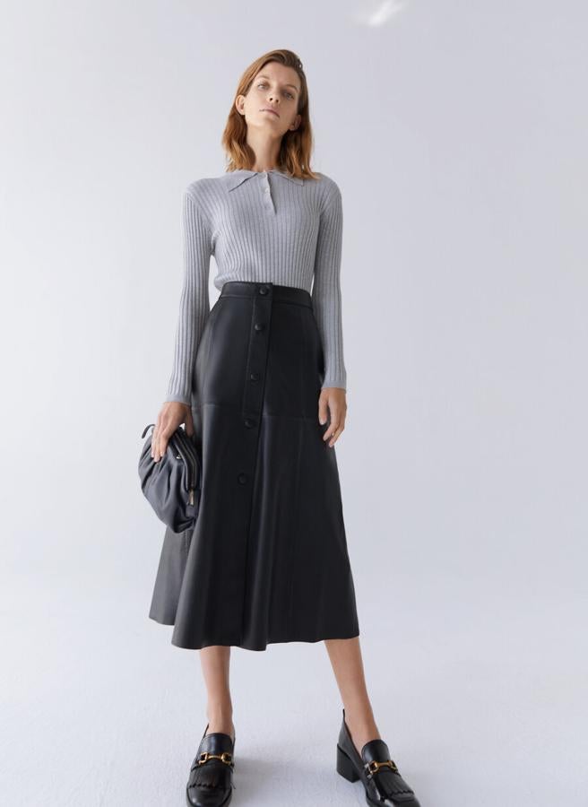 Cierre frontal de botones a tono para esta falda midi confeccionada en piel de alta calidad con diseño de paneles y costuras vistas a tono, en color negro. Con un precio de 199 euros, podemos encontrarla en las tallas S, M y L.