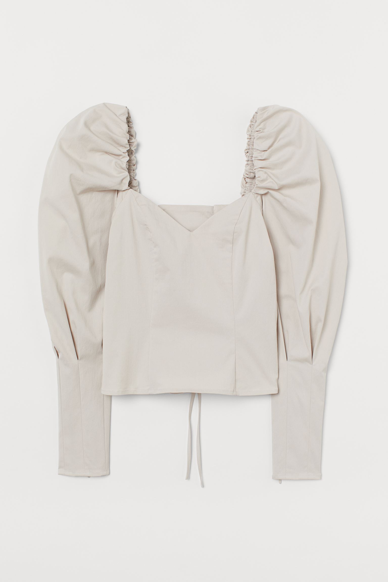 Blusa con manga puffy, escote a pico y espalda con lazada tipo corset. De la nueva colección de H&M. (39,99 euros).