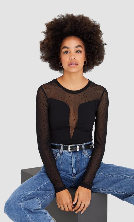 De cuello redondo y manga larga, este body negro de Stradivarius con transparencias y detalles de plumetti tiene un precio de 15,99 euros y está disponible en las tallas S, M y L.