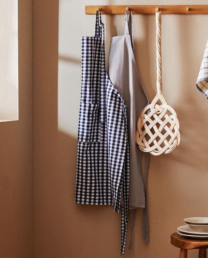 Este delantal de algodón con estampado de cuadros en blanco y negro tiene un precio de 15,99 euros.
