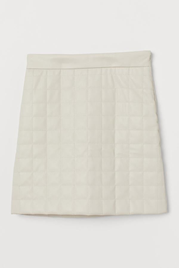 Esta falda corta guateada en piel sintética de color blanco cuenta con cintura alta y cremallera oculta en un lateral. Tiene un precio de 29,99 euros.