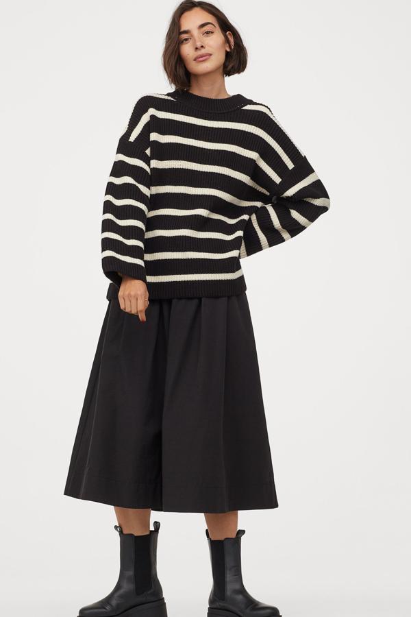 En color negro con rayas en crudo, este jersey en punto de canalé cuenta con cuello redondo y mangas amplias. Es de H&M y tiene un precio de 19,99 euros.
