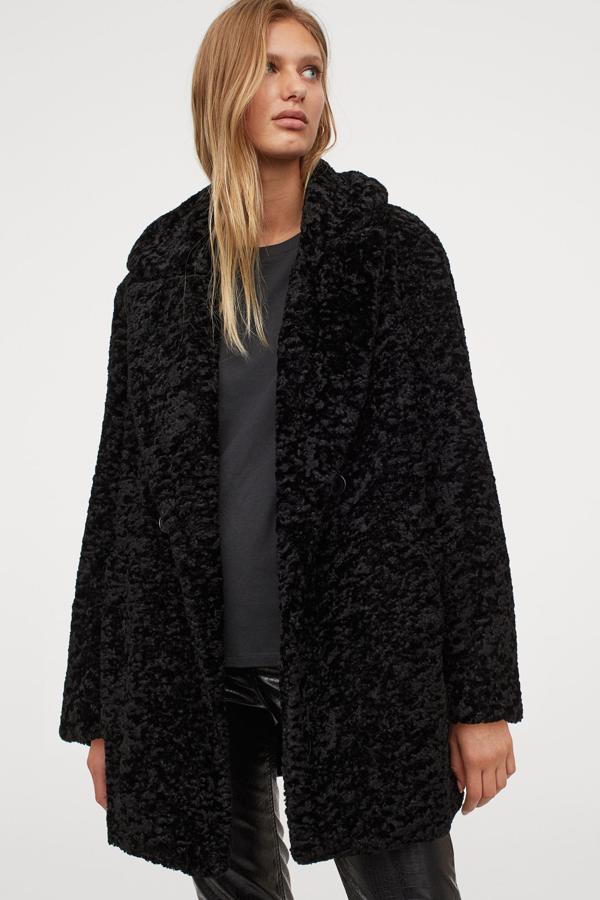 Disponible en negro, beige claro y beige oscuro, este abrigo en pelo sintético suave con doble botonadura y bolsillos al bies ribeteados es de H&M y tiene un precio de 59,99 euros.