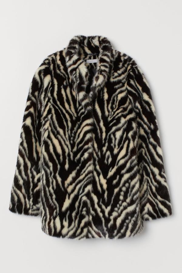 Esta chaqueta de pelo sintético con estampado de cebra cuenta con botones a presión ocultos y cuello alto. Está rebajada a la mitad de su precio y ahora cuesta 49,99 euros. Es de H&M.