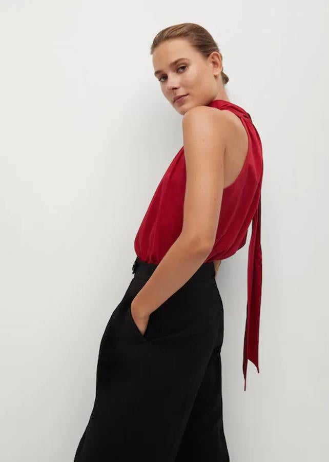 Tus estilismos de fiesta estarán solucionados con un pantalón negro y este top rojo de Mango con cuello halter, cierre de lazo en el cuello y mangas sisa. Tiene un precio de 19,99 euros y está disponible entre las tallas XS y XL.