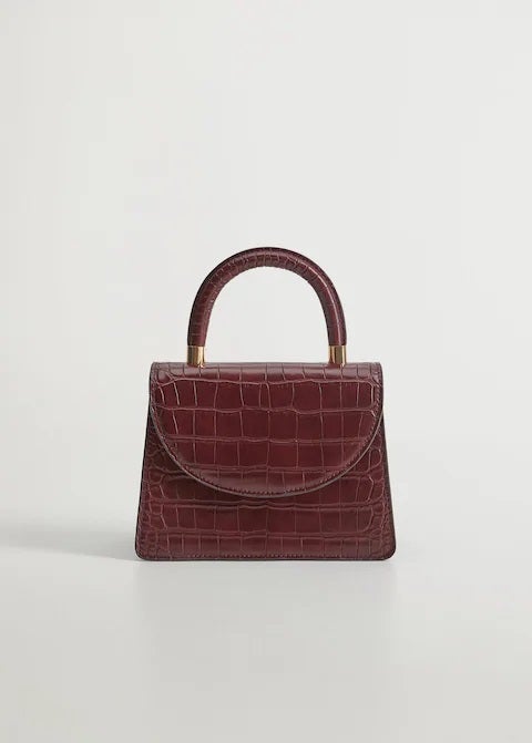 Bolso mini en tono burdeos con piel efecto cocodrilo para looks de estilo infinito. (19,99 euros).