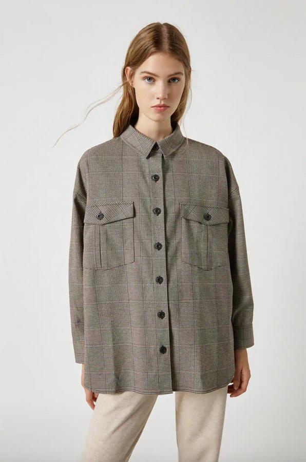 Si además de vestir cómoda quieres ir a la última, esta camisa con estampado Príncipe de Gales de Pull&Bear puede ser tu prenda. Con mangas largas, cuello clásico, cierre de botones negros en el frontal y detalle de bolsillos de tapeta con solapas en el pecho, cuesta 25,99 euros y está disponible en las tallas S, M y L.