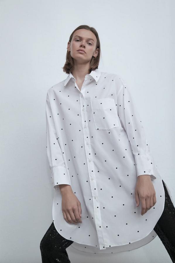 Confeccionada con algodón 100% orgánico, esta camisa oversize de Zara con cuello de solapa y mangas largas viene con estampado de lunares a contraste en negro y bolsillo delantero de plastrón. Cuesta 19,95 euros y solo queda en las tallas XS y S.