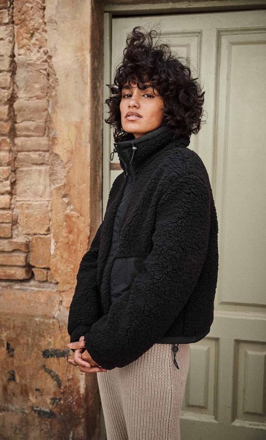 De cuello subido ajustable con cordón, esta cazadora bimateria con borreguito viene con bolsillos delanteros en diferente tejido en el mismo tono. Con cierre frontal de cremallera, tiene un precio de 25,99 euros y está disponible entre las tallas XS y XL y en color beige.