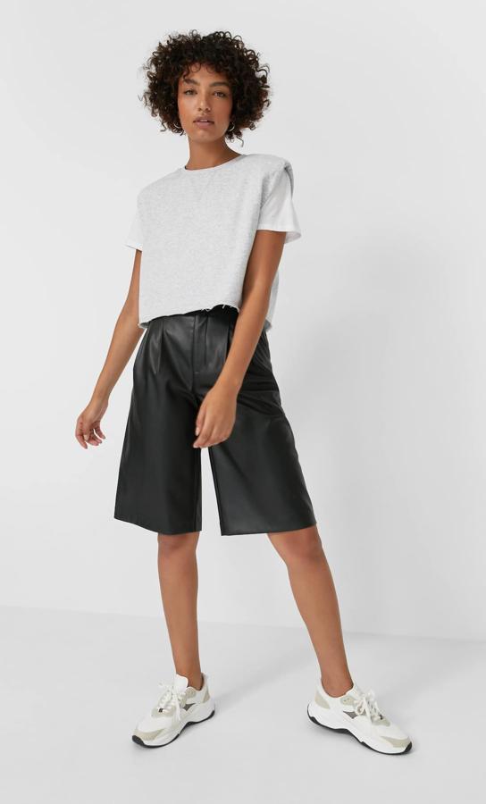 Desenfadado y urbano, con zapatillas de deporte y una csemiseta de algodón deshilachada, de Stradivarius (19,99 €).