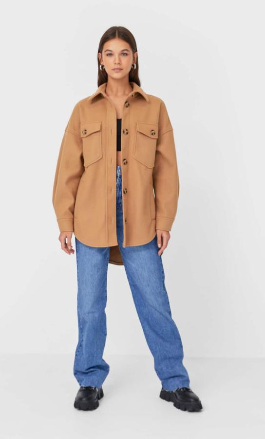 Confeccionada en punto fit con diseño oversize, cuello solapa y mangas largas, esta sobrecamisa de Stradivarius en camel oscuro viene con bolsillos de plastrón en el pecho y bajo asimétrico. Cuesta 29,99 euros y podemos encontrarla entre las tallas XS y XL y en colores como el negro o dos tonos de gris.