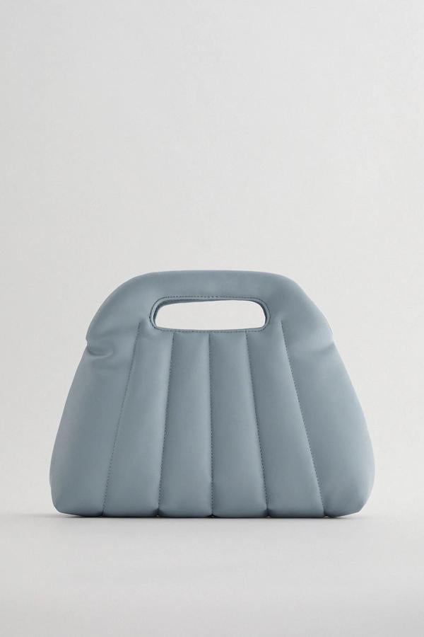 Disponible en azul o caqui, este bolso con cuerpo acolchado con detalle de costuras cuenta con asas de mano y asa de hombro ajustable y extraíble. Con cierre mediante imán, tiene un precio de 25,95 euros.