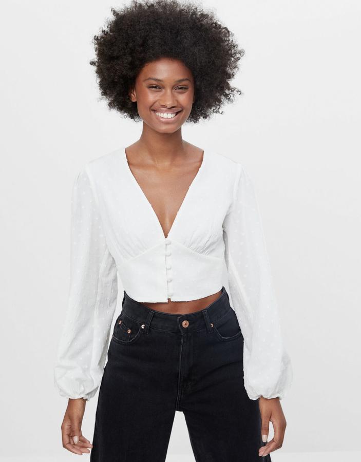 Disponible en blanco o verde, esta blusa de plumeti con pronunciado escote de pico y manga con puño con elástico tiene un precio de 11,99 euros.