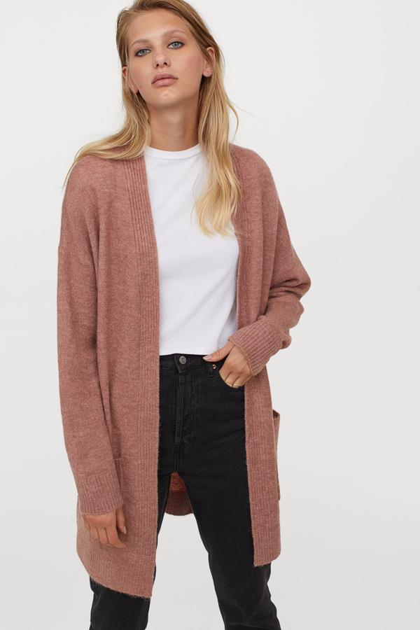 Disponible en color rosa o gris oscuro, este cárdigan en punto fino cuenta con bolsillos delanteros y remate elástico de canalé en puños y bajo. Tiene un precio de 29,99 euros.