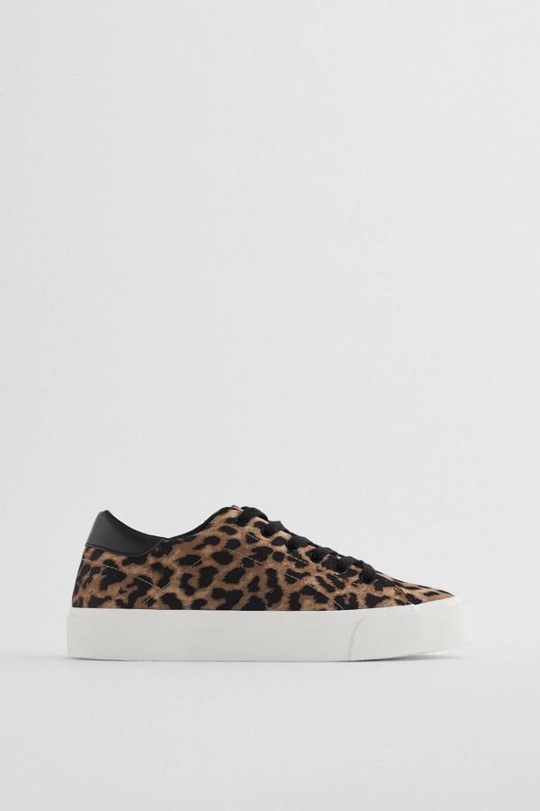 Esta zapatilla deportiva con estampado de leopardo en el corte y suela de tres centímetros de altura en blanco cuenta con cierre mediante botones y tiene un precio de 19,95 euros. Es de Zara.