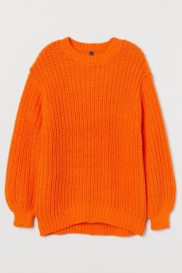 Disponible en naranja, negro o beige, este jersey oversize en punto grueso y con mangas amplias ceñidas en los puños tiene un precio de 29,99 euros.