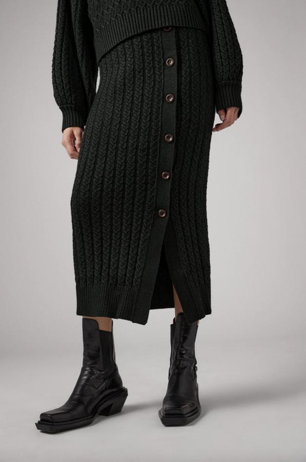 Diseño midi con cintura elástica para esta falda de Zara de punto en gris antracita con dibujo de ochos y detalle de botones laterales y acabados en rib. Tiene un precio de 29,95 euros y está disponible en las tallas S y L.