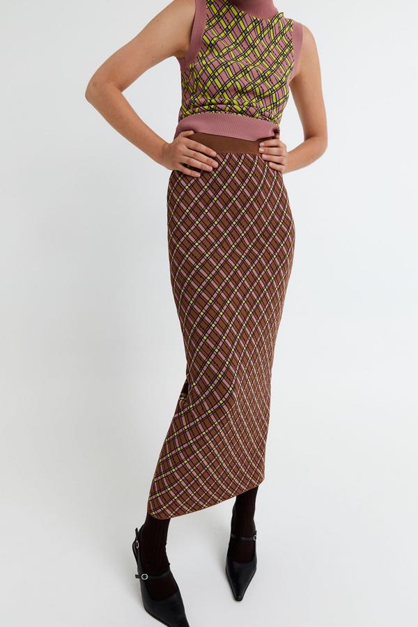 Estampado de cuadros en tonos marrones y verde flúor para esta falda de tubo de Sfera con cintura elástica y largo por debajo de la rodilla. Tiene un precio de 39,99 euros y está disponible en las tallas S, M y L.