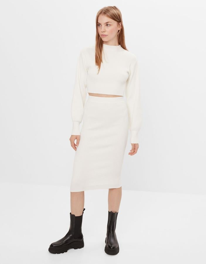 Un poco de blanco que le de alegría al invierno y que nos case perfectamente con un abrigo gris. Este conjunto de falda de tubo (19,99 euros) y jersey cropped de cuello perkins (22,99 euros), todo de canalé, es de Bershka.