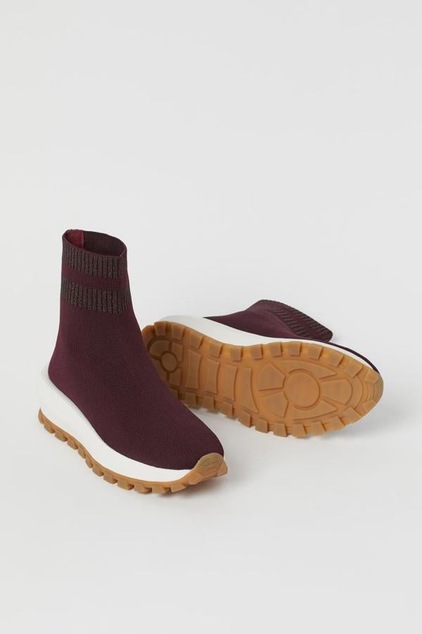 ¿Te atreves con las zapatillas tipo calcetín? Si la respuesta es sí, ficha el modelo que está disponible en H&M. Un diseño en color burdeos y que también está disponible en gris brillante (29,99 euros) con suela gruesa y dentada.