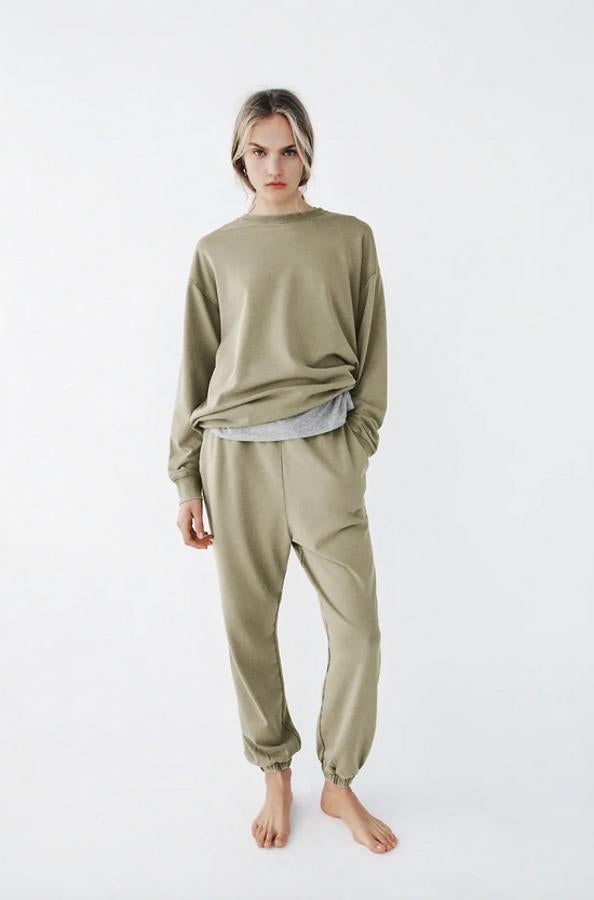 En verde oliva, confeccionado en algodón orgánico, este pantalón de tiro alto con cintura elástica viene con bolsillos laterales y bajo acabado en puño elástico. Tiene un precio de 19,95 euros y está disponible en las tallas S, M y L.