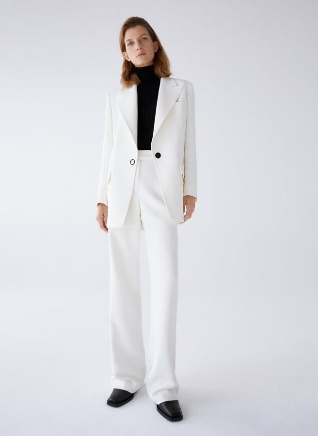 Confeccionada en tejido italiano de alta calidad, esta blazer blanca de Uterqüe viene con bolsillos laterales con tapeta, cierre frontal con snap de anilla a contraste en negro y diseño ligeramente oversize. Tiene un precio de 179 euros y está disponible entre las tallas XS y L.