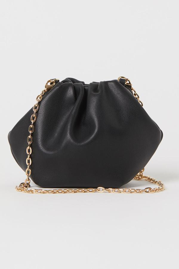 Un bolso de noche ideal, tipo saco en versión mini y, cómo no, con asa de cadena. Lo firma H&M (12,99 euros).