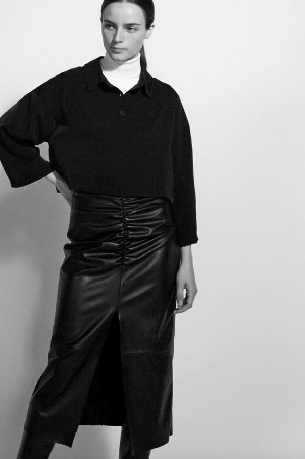 Esta falda de tubo en color negro de Zara viene con detalle de frunce y abertura frontal. Con cierre en la espalda con cremallera oculta en costura, cuesta 29,95 euros y está disponible entre las tallas XS y XXL.