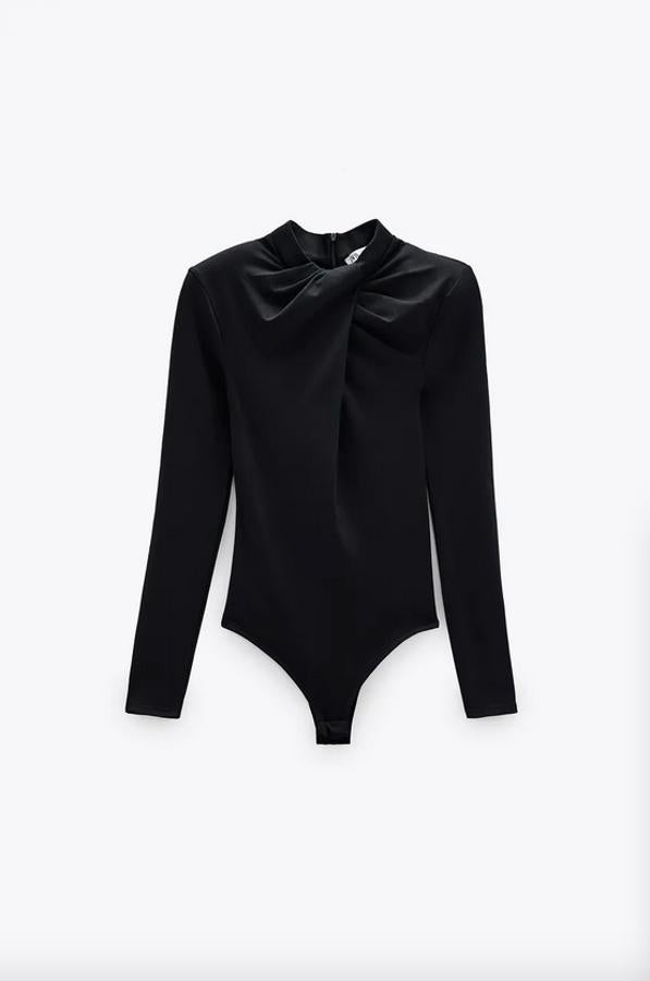 Disponible en rosa claro y en negro, este body de cuello redondo y manga larga con hombreras de Zara viene con detalle de nudo en el frontal. Con un precio de 17,95 euros, está disponible en las tallas M y L.