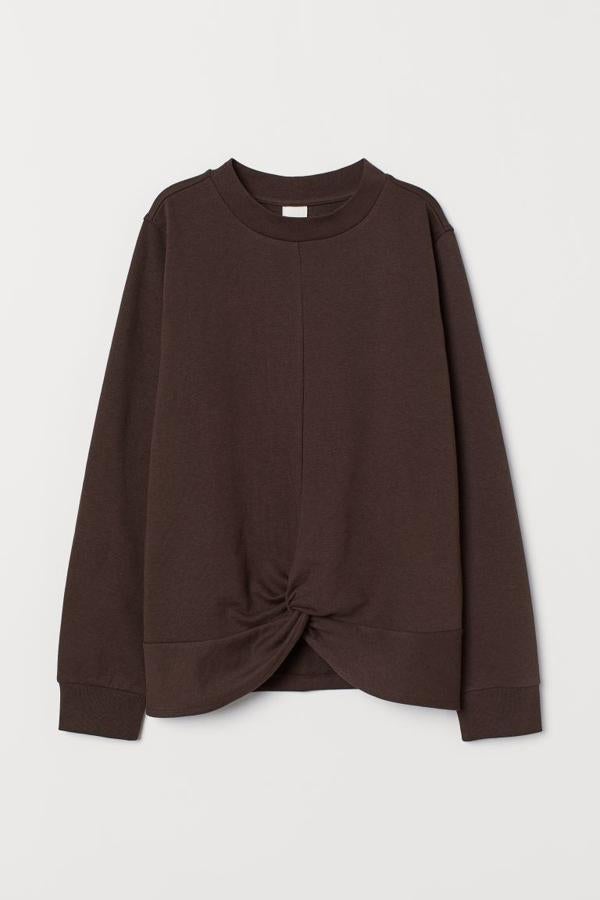 Esta sudadera en tejido ligero con costura visible en el frontal en color marrón es de H&M y viene con detalle de nudo en el bajo y remate ancho en punto elástico en escote y puños. Tiene un precio de 14,99 euros y está disponible únicamente en las tallas XS y S.