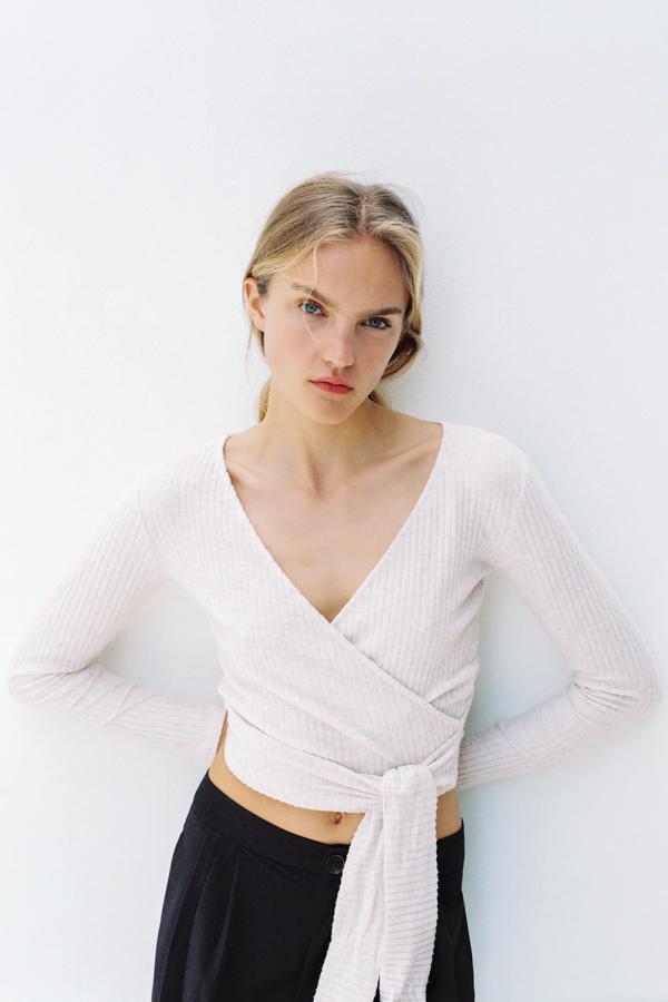 Chaqueta cruzada de punto suave en blanco roto, de Zara (15.99 euros).
