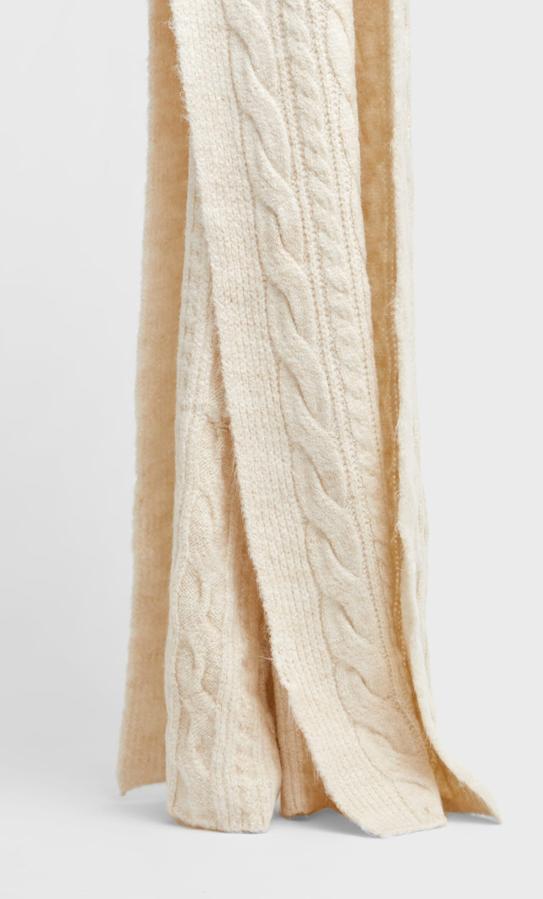 Disponible en crudo y en gris, esta bufanda de punto con diseño de ochos es de Stradivarius y cuesta 19,99 euros.