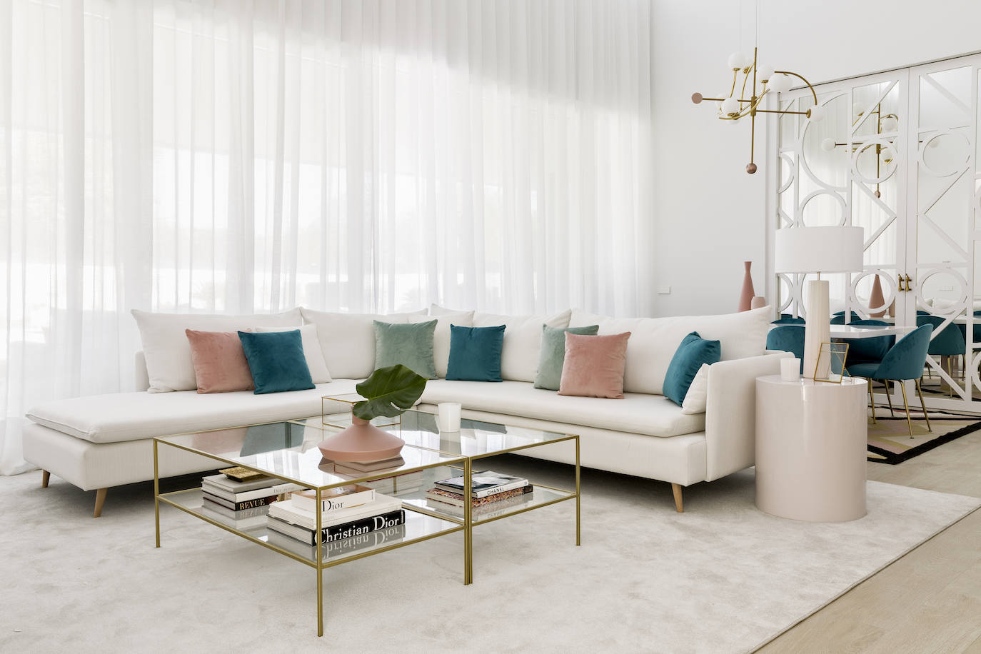 En el salón principal de la casa de Paula Echevarría, un espacio lleno de luz que desprende inspiración en cada rincón, encontramos "un gran sofá Danko tapizado en color blanco blanco se convierte en el marco perfecto para un ambiente donde destacan los tonos rosa, menta y aguamarina de los cojines de Velvet, además del dorador de las dos mesas de centro Gold", nos detallan desde Kenay Home.