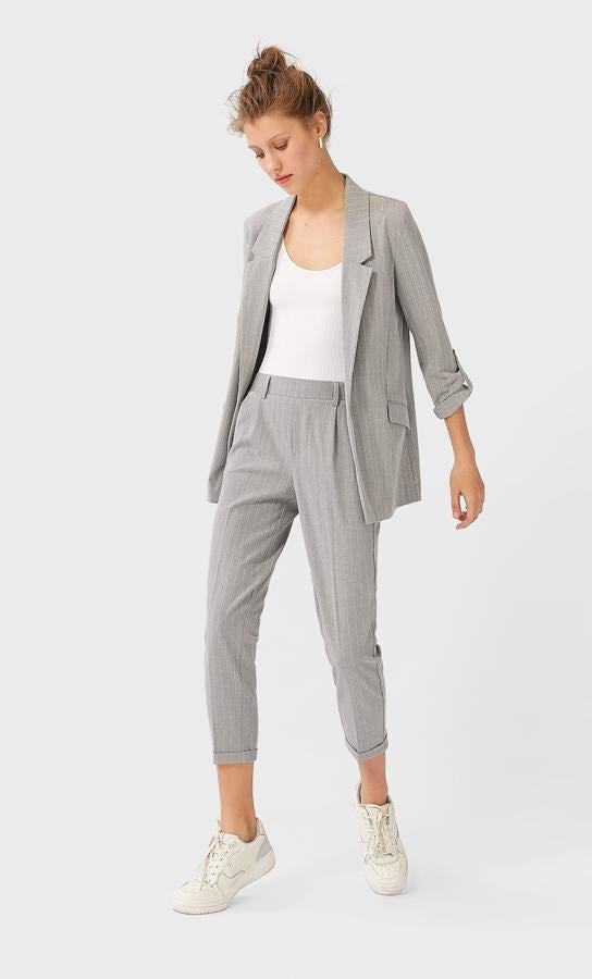 Traje en gris claro de americana (25,99 euros) y pantalón con vuelta en el bajo (17,99 euros), de Stradivarius.