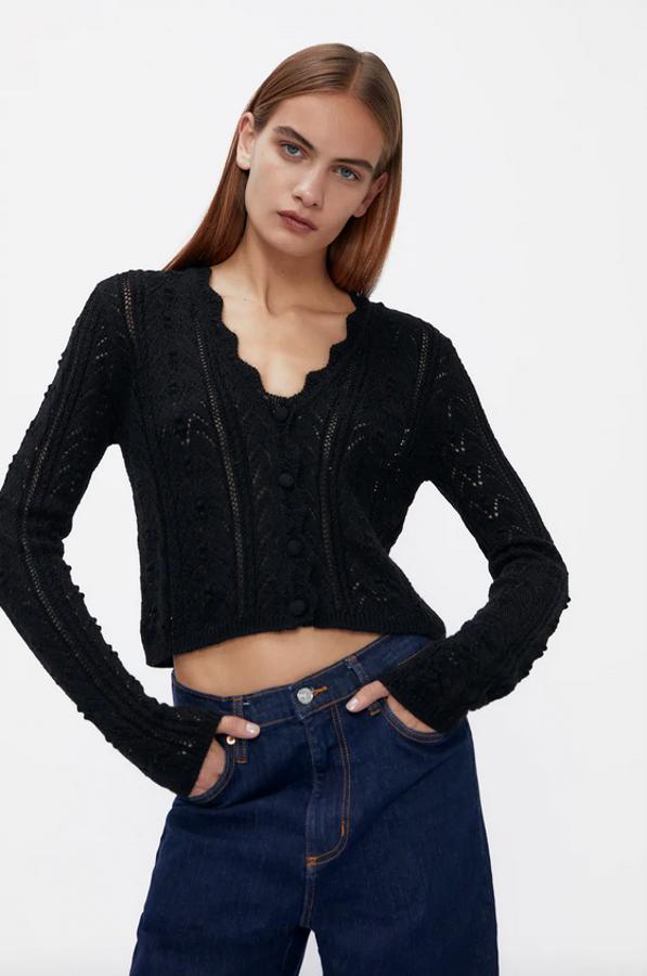 Diseño entallado para esta chaqueta de punto en color negro con escote de pico y mangas largas. Con diseño pointelle y cierre frontal de botones a tono, es de Zara, tiene un precio de 19,95 euros y está disponible en las tallas S, M y L.