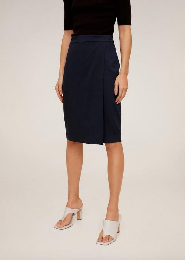 En azul marino, con diseño medio cruzado, tiro alto y cierre de cremallera en la parte posterior, esta falda de Mango tiene un precio de 25,99 euros y está disponible entre las tallas 34 y 42.