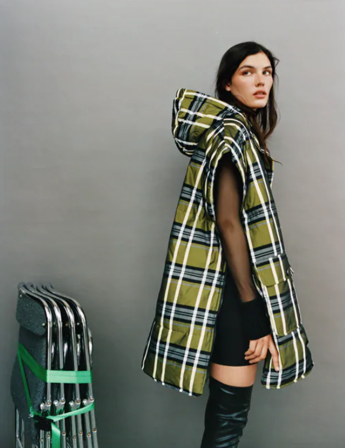 Chaleco acolchado de Zara (49,95 euros) con el cuello subido con capucha y manga sisa. Lleva bolsillos delanteros de plastrón con solapa y cierra en el frontal con botones metálicos.