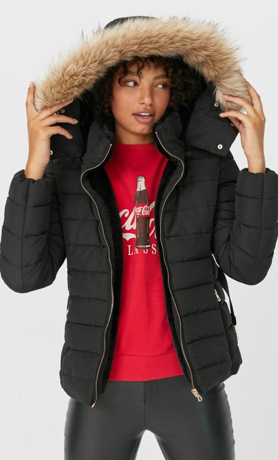 En color negro, este plumífero entallado con cuello subido y capucha extraíble con aplicación efecto pelo cuenta con cinturón del mismo tejido. Es de Stradivarius y tiene un precio de 49,99 euros.